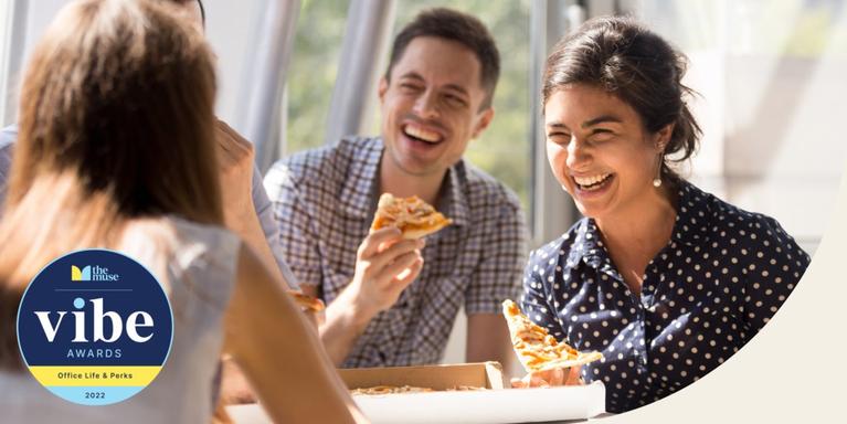 three people eating pizza and laughing