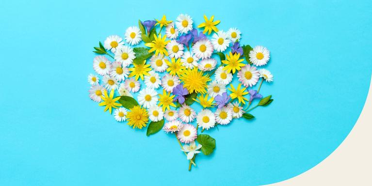 image of white, yellow, and purple flowers with green leaves arranged in the shape of a brain against a bright blue background
