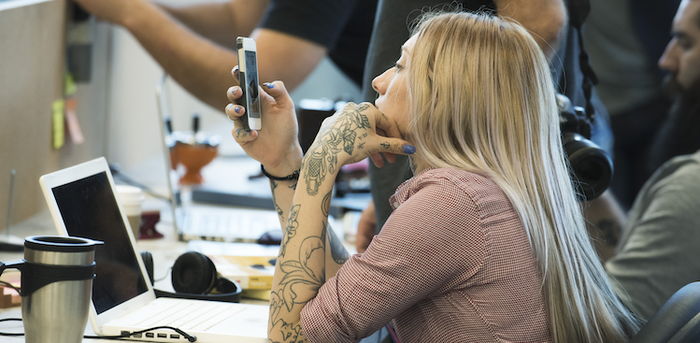 person staring at her cell phone at the office