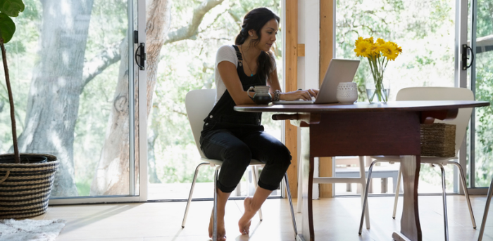 woman working at laptop at dining table