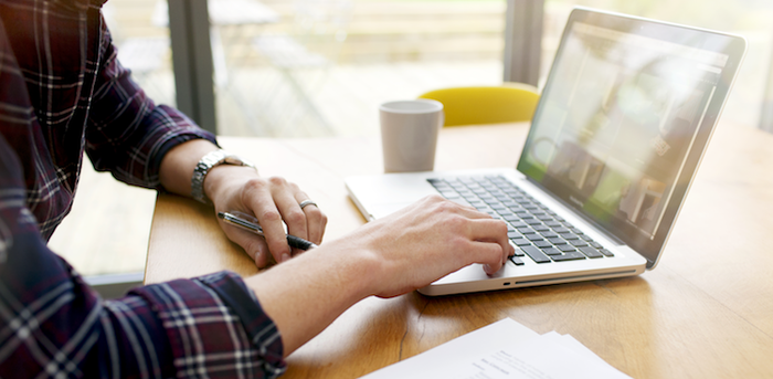 person sitting in front of a laptop working remotely