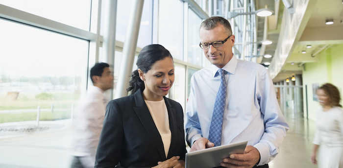 two people looking a tablet in an office