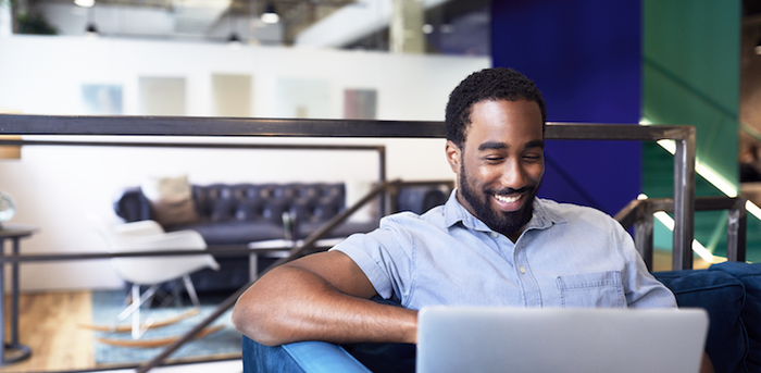 person sitting on a couch using a laptop