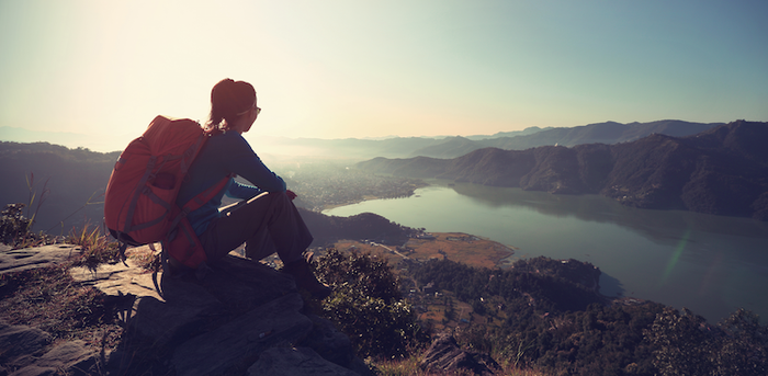 person sitting on a rock after hiking