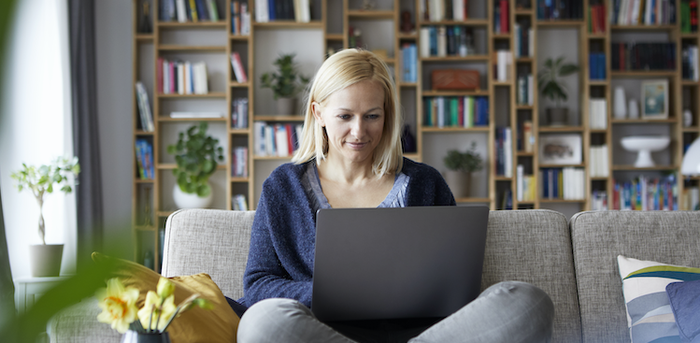 person sitting on a couch working on a laptop