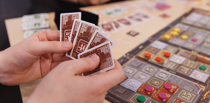 people playing the board game Chinatown