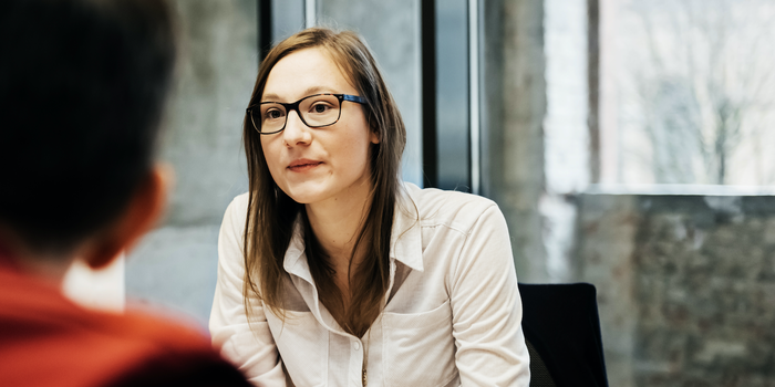 two people sitting across from one another in an office having a conversation