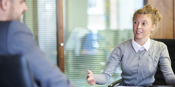 person sitting down in an office across from an interviewer during an internship interview