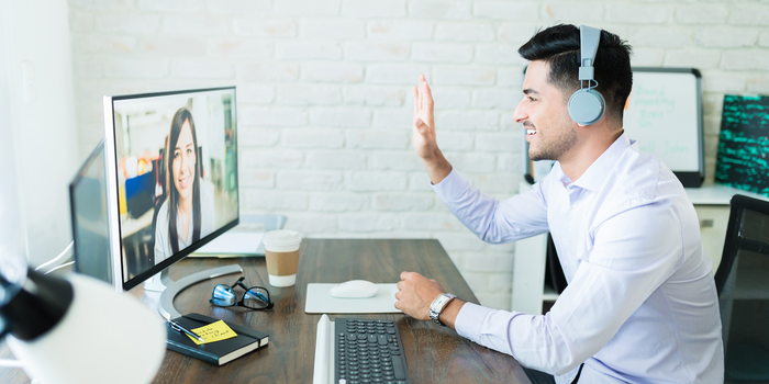 person sitting in front of a monitor wearing a headphone during a video interview