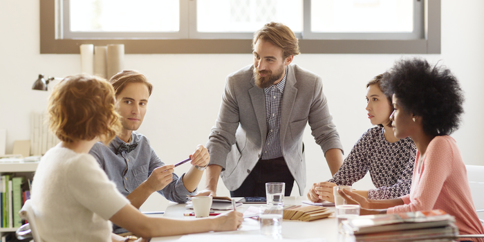 coworkers, including one Black woman, in a meeting at the office