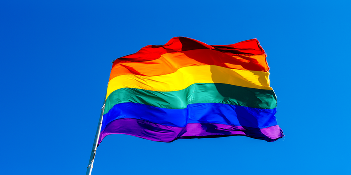 Rainbow flag against a blue sky