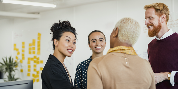 diverse group of people standing and chatting in a professional setting