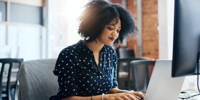 person sitting in an office working on a laptop