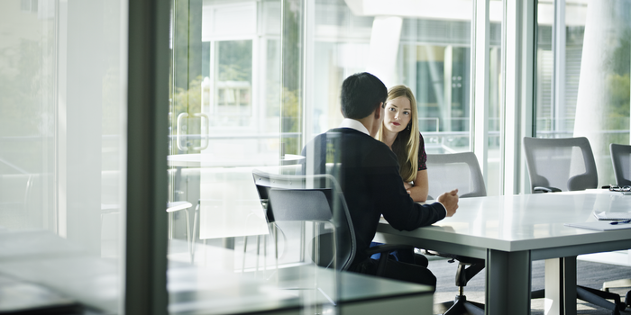 two people sitting at a conference room table during an interview