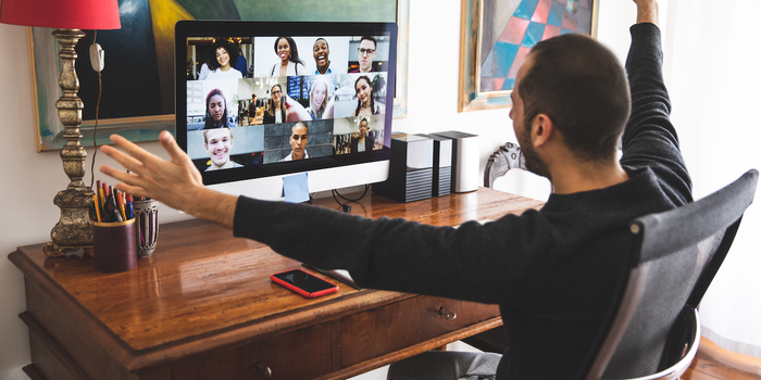 person sitting at a desk on a video call with multiple people