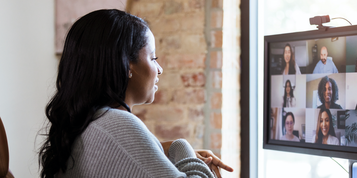 person sitting in front of a computer screen on a video call with coworkers