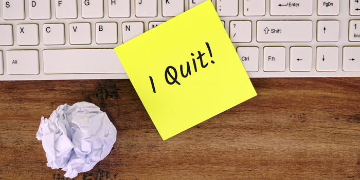 yellow sticky note that says, "I quit!" on a keyboard with a crumpled paper next to it
