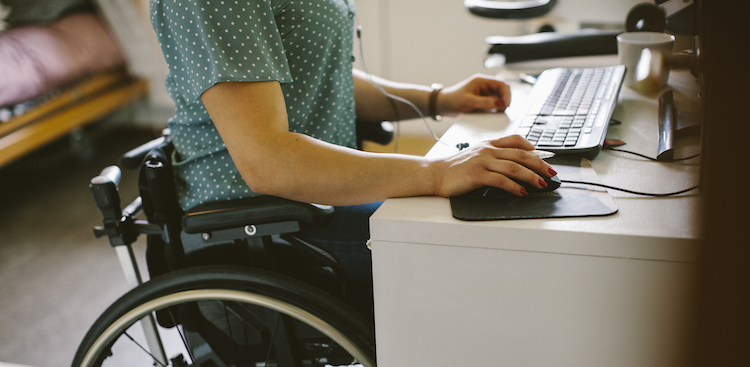 person sitting in a wheelchair and using a computer