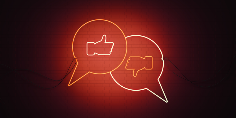 two neon speech bubbles, one with a thumbs up and the other a thumbs down, in shades of white and red against a black background