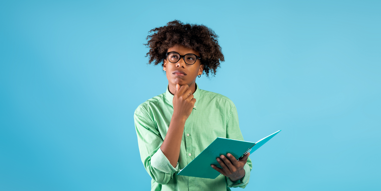 person in a green shirt and glasses thinking hard with the face tilted up on the diagonal and hand to their chin, while the other hand holds an open book, against a blue background