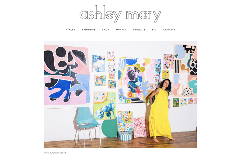 screenshot of the homepage of ashleymary.com featuring a photo of Ashley Mary with her artwork